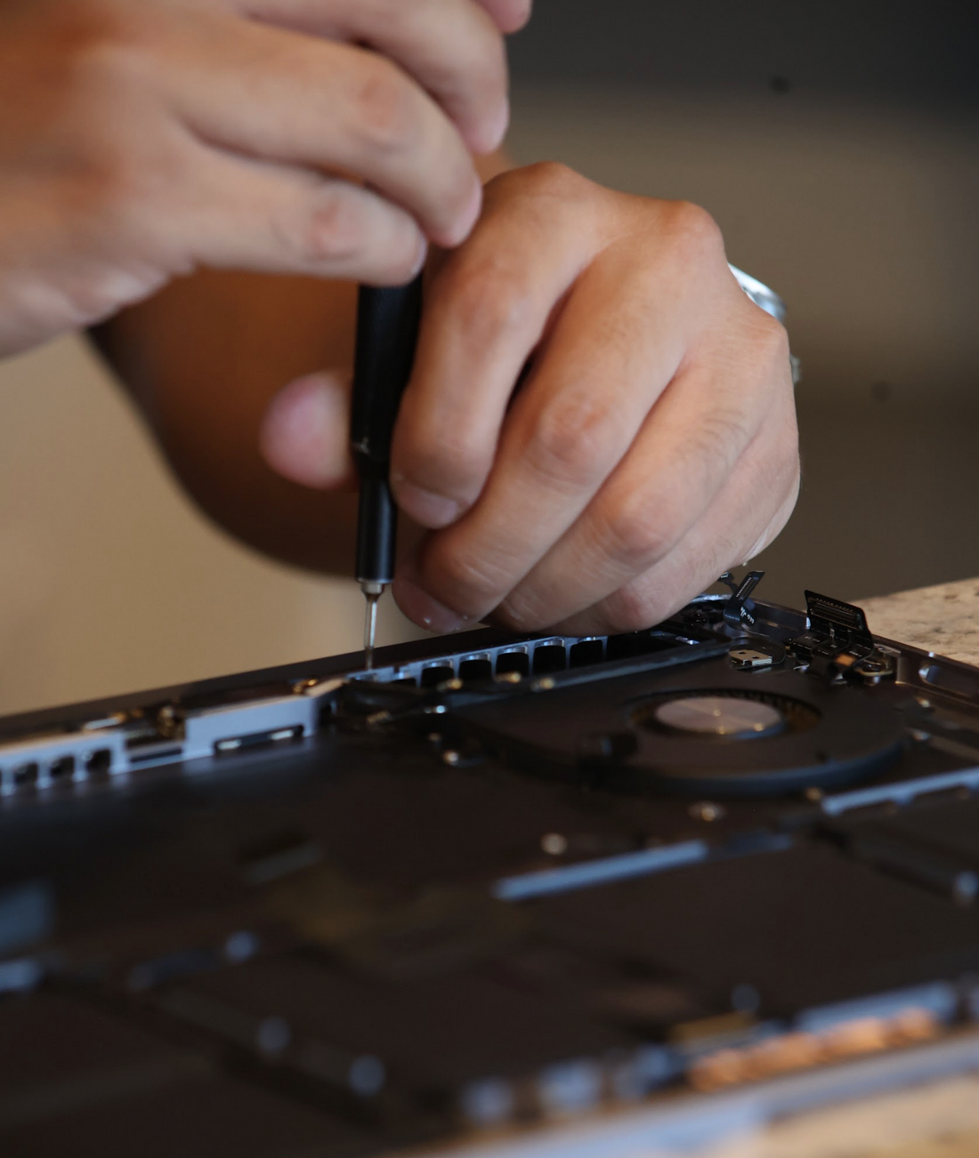 Close-up of board-level computer repair at DC Computers in San Diego, working on the interior of a device